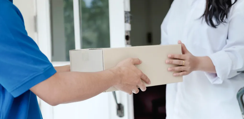 Delivery person handing a box to another person